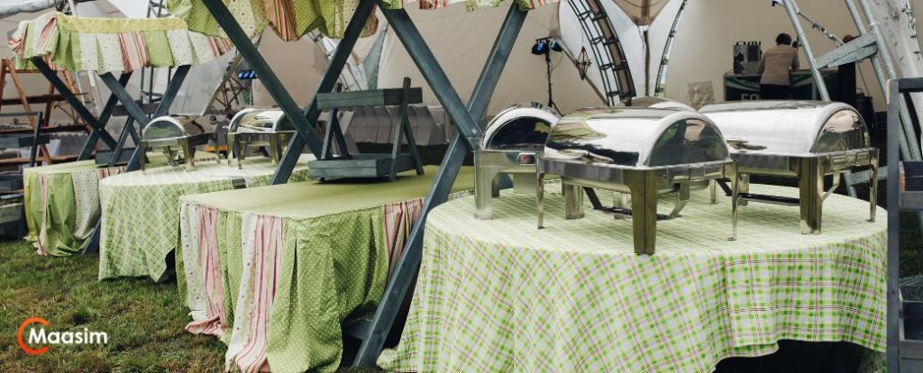 אירוע חברה בטבע - ניתן לראות שולחנות וכיסאות באירוע ובצד שמאל למטה לוגו אתר MAASIM